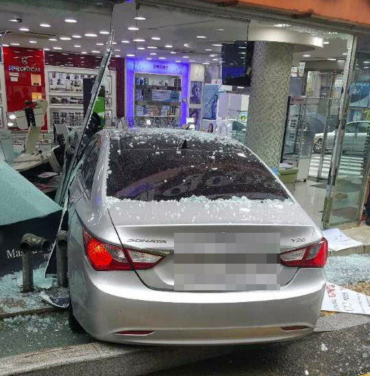 3일 오전 10시 12분께 부산 금정구 구서동의 한 안경점에 소나타 차량이 돌진해 유리창이 부서져 있다. 경찰은 교차로에서 택시에 추돌 당한 소나타 차량이 상점으로 돌진한 것으로 보고 정확한 사고 경위를 조사하고 있다.  <부산 금정경찰서 제공>